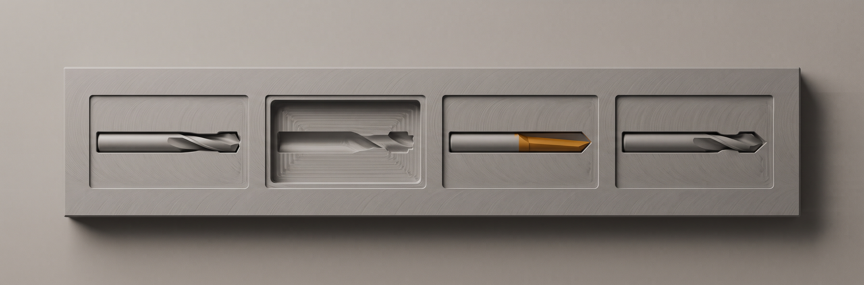 A machined panel with three tool bits set flush into recesses cut into its own face, and a fourth recess left empty.